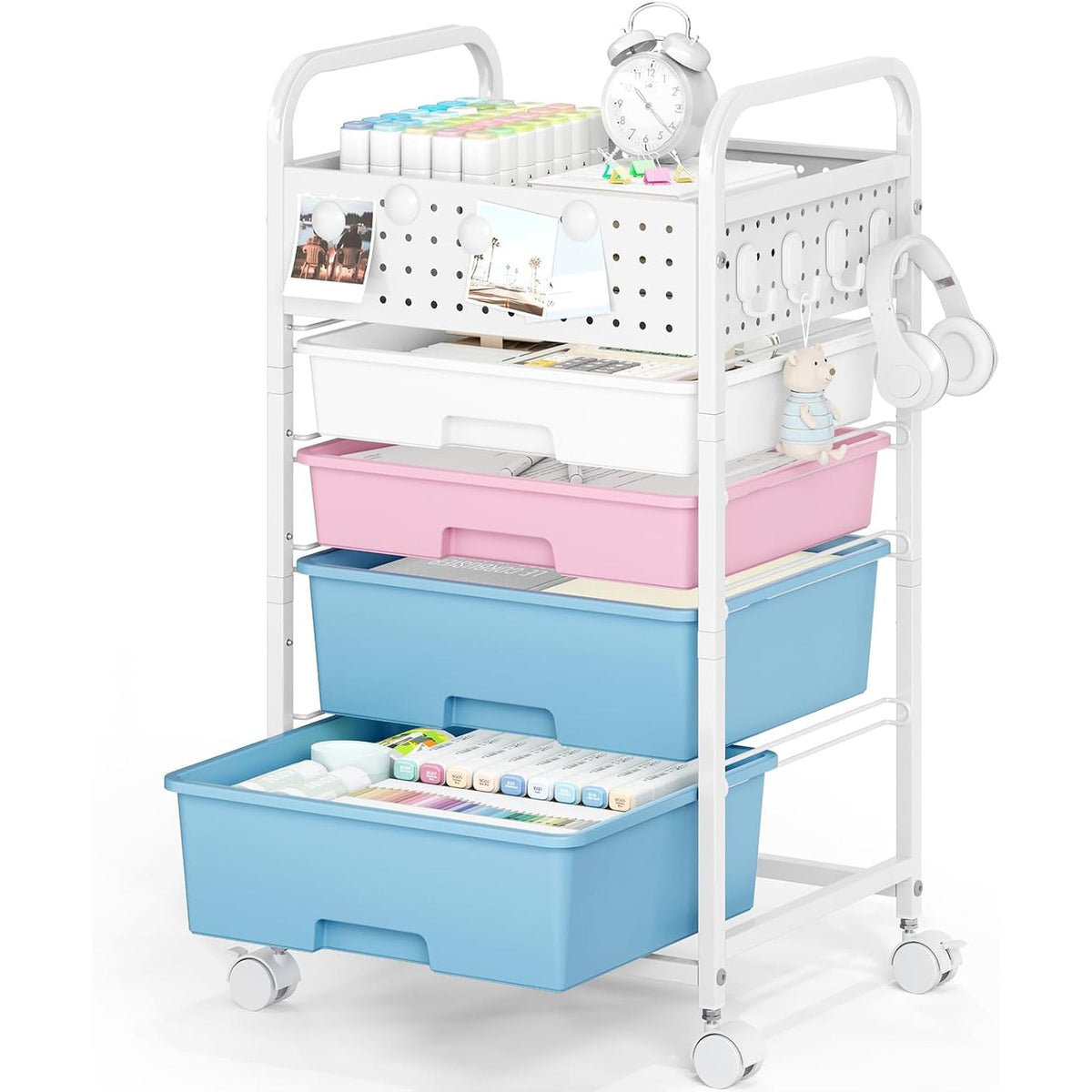 SYKIARIOL rolling storage cart with pegboard top, pastel pink and blue drawers with an alarm clock and headphones on top